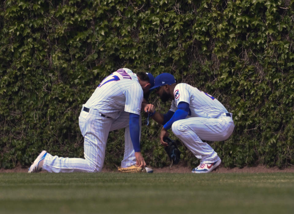 Chicago Cubs center fielder Jason Heyward, right, and right fielder Kris Bryant (17) take a moment after colliding while chasing a ball hit by Cincinnati Reds'c Eugenio Suarez (7) during the sixth inning of a baseball game Sunday, May 26, 2019, in Chicago. Bryant was charged with an error on the play.(AP Photo/Matt Marton)