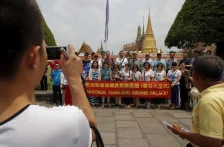 Chinese tourists pose for photos as they visit Wat Phra Kaeo (Emerald Buddha Temple) in Bangkok March 23, 2015. REUTERS/Chaiwat Subprasom