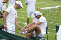 Rafael Nadal of Spain, right, adjusts bandages on his foot during a practice session ahead of the 2022 Wimbledon Championship at the All England Lawn Tennis and Croquet Club, Wimbledon, England in London, Friday, June 24, 2022. (AP Photo/Kirsty Wigglesworth)