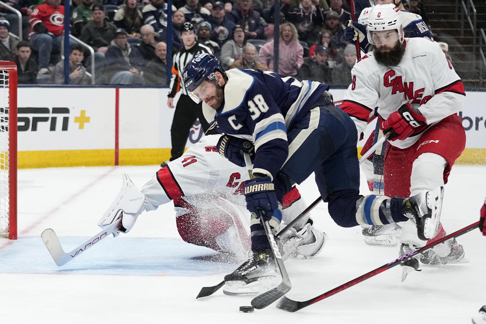 Columbus Blue Jackets center Boone Jenner (38) reaches for the puck in front of Carolina Hurricanes goaltender Spencer Martin (41) during the second period of an NHL hockey game Thursday, Feb. 29, 2024, in Columbus, Ohio. (AP Photo/Sue Ogrocki)