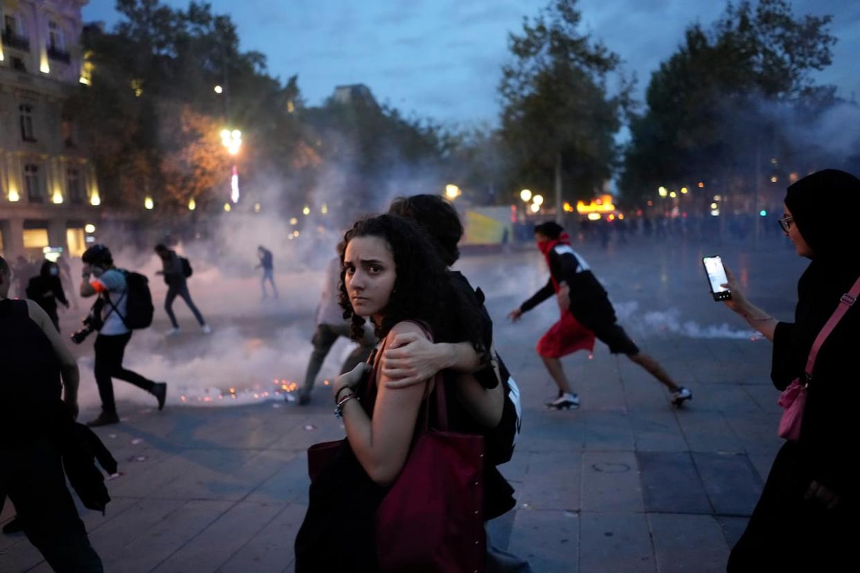 Protesters walk on the Republique square as riot police use tear gas during a rally in solidarity with the Palestinian people in Gaza, in Paris, Thursday, Oct.12, 2023. (Thibault Camus/AP - image credit)