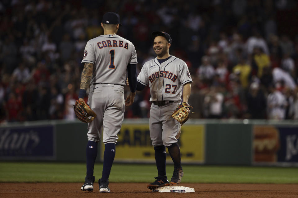 Houston Astros Jose Altuve, (27) smiles at teammate Carlos Correa as they take the field for the ninth inning of Game 5 of the American League Championship Series against the Boston Red Sox Wednesday, Oct. 20, 2021, at Fenway Park in Boston. (AP Photo/Winslow Townson)