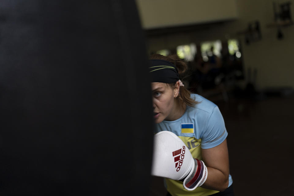 Ukrainian boxer Anna Lysenko hits a punching bag while training at Kiko Boxing Club in Kyiv, Ukraine, Tuesday, July 11, 2023. Lysenko dedicates long hours preparing for next year's Paris Olympics despite the unsettling sounds of explosions booming outside. (AP Photo/Jae C. Hong)