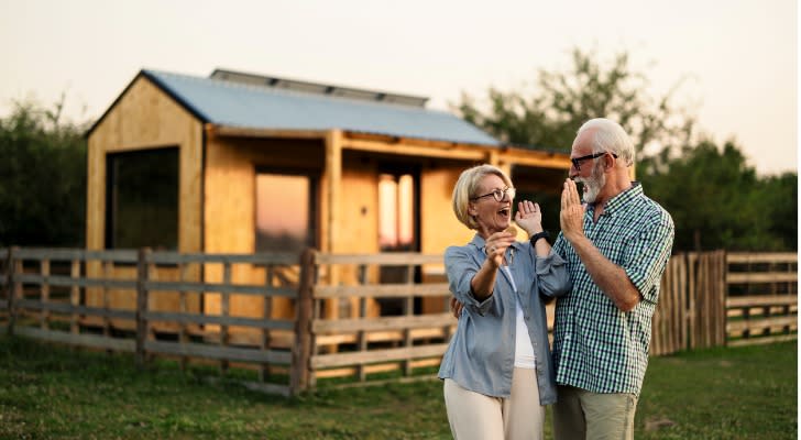 A couple celebrating after closing a deal with a real estate investing company.