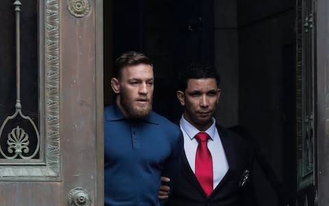 McGregor walks out of New York's 78th police precinct after being charged with attacking a bus earlier this year - Credit: Reuters