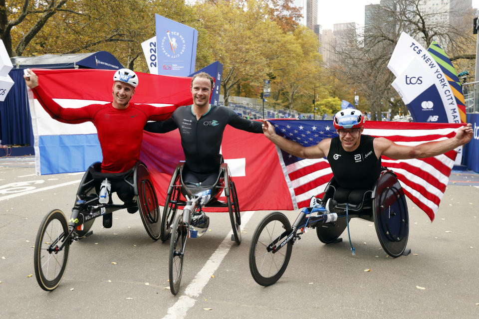 From left, men's wheelchair division third place finisher Jetze Plat, of the Netherlands, winner Marcel Hug, of Switzerland, and second place finisher Daniel Romanchuk pose at the finish line of the New York City Marathon, Sunday, Nov. 6, 2022, in New York. (AP Photo/Jason DeCrow)