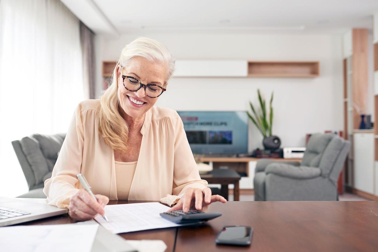 smiling mature woman calculating expenses