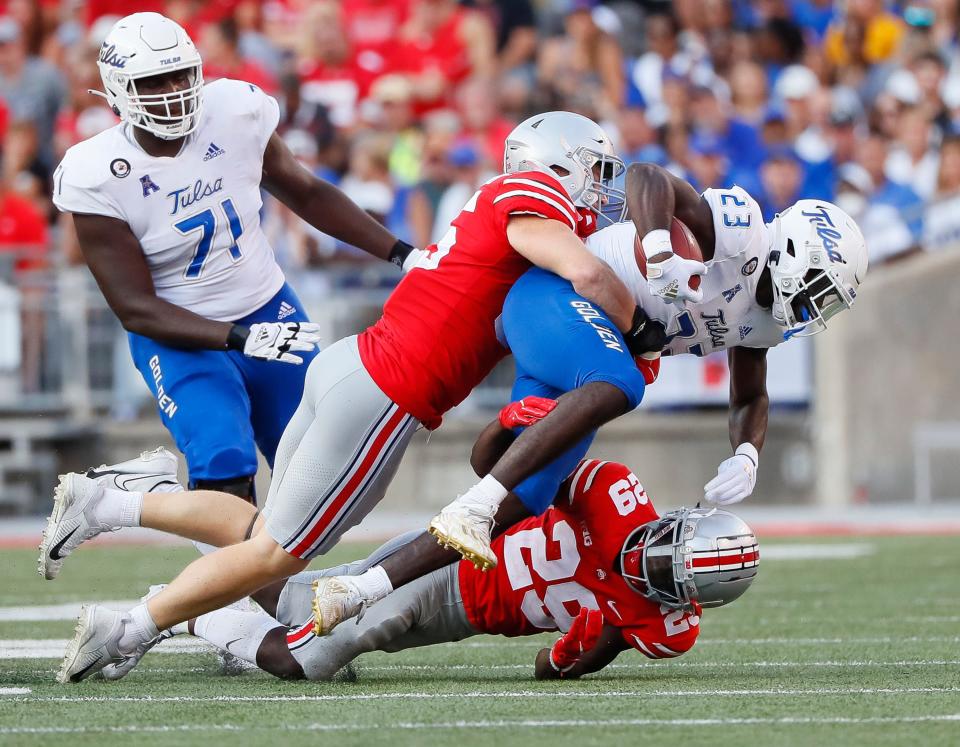 Ohio State's Tommy Eichenberg (left) and Denzel Burke tackle Tulsa running back Anthony Watkins. The Buckeyes ranked No. 59 in total defense last year.