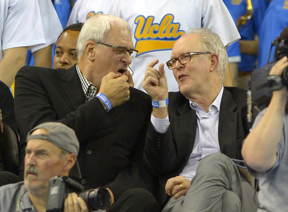 Former NBA coach Phil Jackson, left, and actor John Lithgow talk as they watch UCLA play Arizona during the first half of an NCAA college basketball game on Thursday, Jan. 9, 2014, in Los Angeles. (AP Photo/Mark J. Terrill)