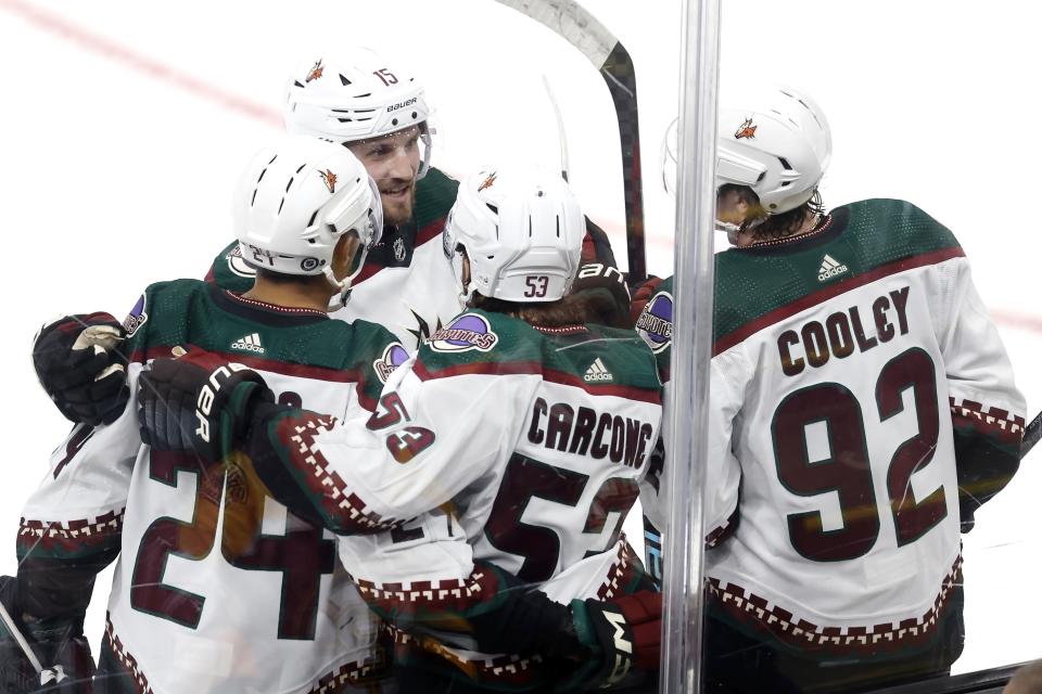 Arizona Coyotes' Michael Carcone (53) celebrates his goal with teammates Matt Dumba (24), Alexander Kerfoot (15) and Logan Cooley (92) during the second period of an NHL hockey game against the Boston Bruins, Saturday, Dec. 9 2023, in Boston. (AP Photo/Michael Dwyer)