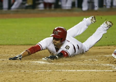 Arizona Diamondbacks' Prado dives across home plate as he scores against St. Louis Cardinals during their MLB National League baseball game in Phoenix