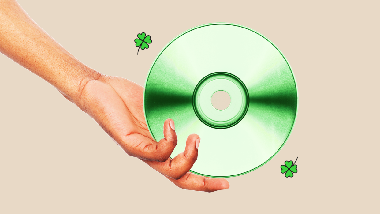an arm and hand holding a cd that is tinted green
