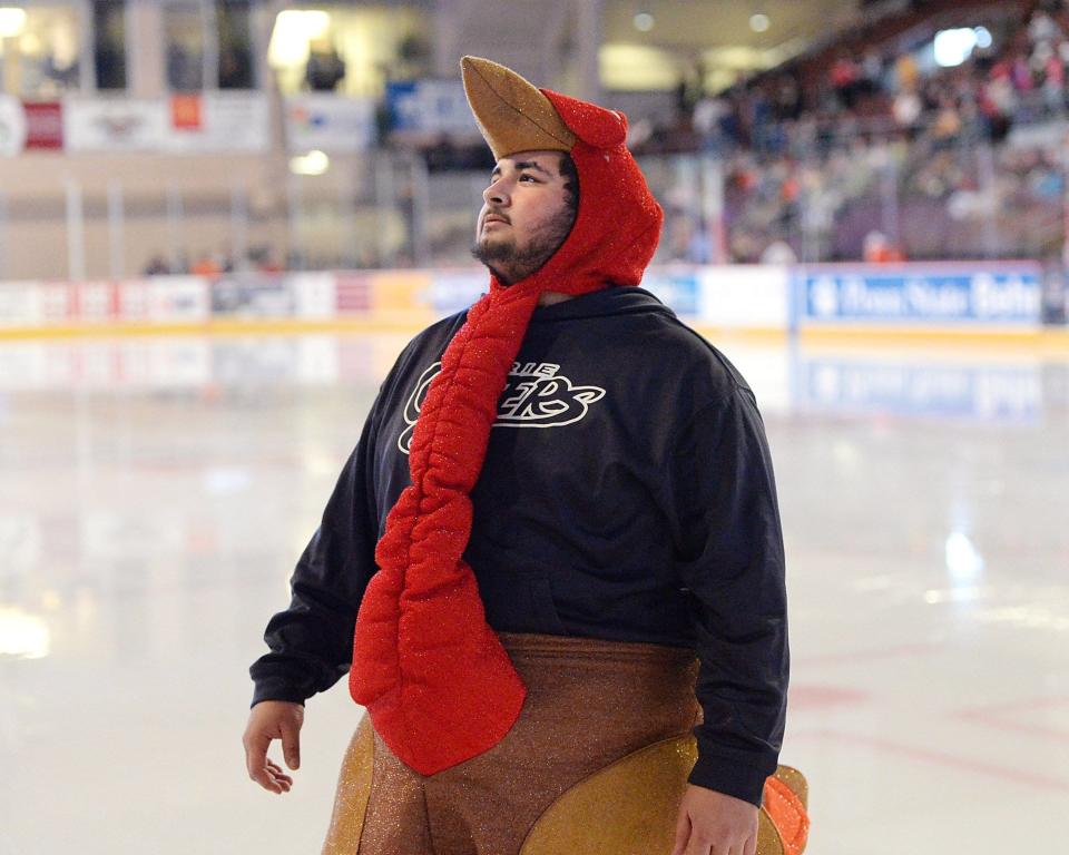 Miene Al-Shamary, involved with Erie Otters game-day operations, tosses t-shirts into the crowd between periods against the Kitchener Rangers at Erie Insurance Arena on Thanksgiving Day 2015. The Otters beat the Rangers 3-2.