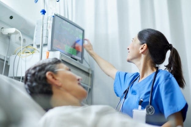 A nurse assists a hospital patient