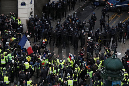 Protesters wearing yellow vests face off with French Gendarmes during clashes on the Champs-Elysees Avenue as part of a demonstration by the "yellow vests" movement in Paris, France, December 8, 2018. REUTERS/Benoit Tessier