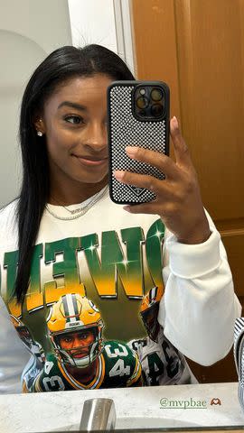 <p>Simone Biles/Instagram</p> Simone Biles wears sweatshirt with her husband's name and face on it.