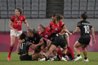 New Zealand and Britain players battling for the ball look up toward an official, in their women's rugby sevens match at the 2020 Summer Olympics, Thursday, July 29, 2021 in Tokyo, Japan. (AP Photo/Shuji Kajiyama)