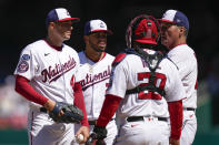 Washington Nationals starting pitcher Patrick Corbin, left, meets on the mound with shortstop Luis Garcia, from left, catcher Keibert Ruiz and pitching coach Jim Hickey during the second inning of an opening day baseball game against the Atlanta Braves at Nationals Park, Thursday, March 30, 2023, in Washington. (AP Photo/Alex Brandon)