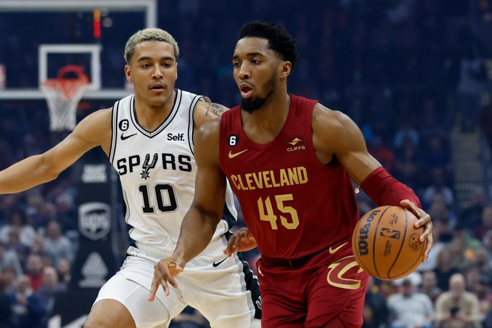 Cleveland Cavaliers guard Donovan Mitchell (45) drives against San Antonio Spurs forward Jeremy Sochan (10) during the first half of an NBA basketball game, Monday, Feb. 13, 2023, in Cleveland. (AP Photo/Ron Schwane)