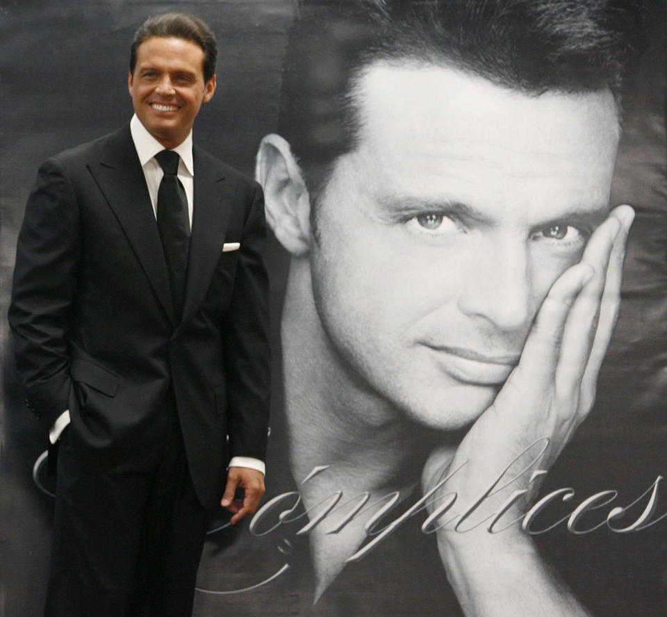 Mexican singer Luis Miguel poses next to a poster of himself during a photocall before a news conference in Mexico City, May 6, 2008. Miguel is on tour to promote his new album 