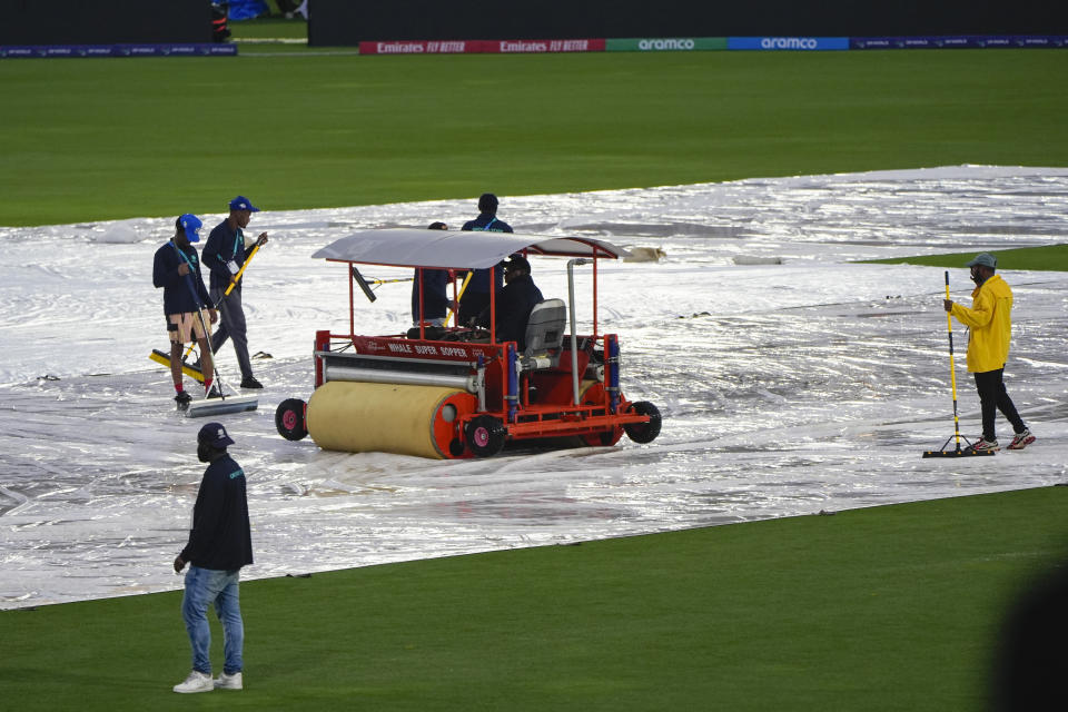 Groundsmen sweep water from the covers as rain delays the start of the men's T20 World Cup cricket match between Sri Lanka and Nepal at Central Broward Regional Park Stadium, Lauderhill, Florida, Tuesday, June 11, 2024. The match was abandoned due to rain. (AP Photo/Lynne Sladky)