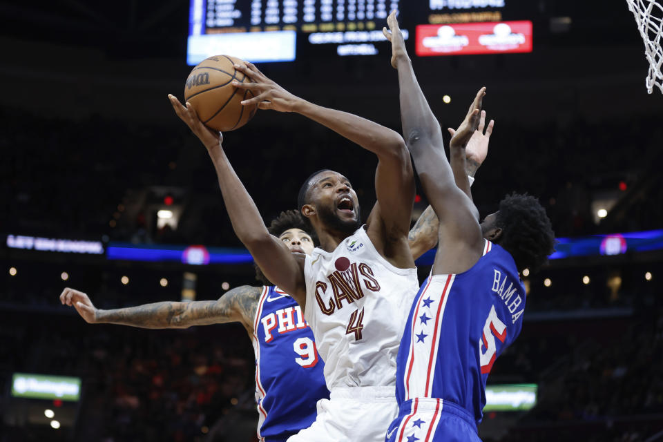 Cleveland Cavaliers forward Evan Mobley (4) shoots against Philadelphia 76ers center Mo Bamba (5) and guard Kelly Oubre Jr. (9) during the second half of an NBA basketball game Friday, March 29, 2024, in Cleveland. (AP Photo/Ron Schwane)