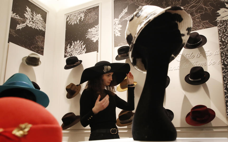 A girl wears a creation as part of the Borsalino women's Fall Winter 2021-22 collection, unveiled during the Fashion Week in Milan, Italy, Wednesday, Feb. 24, 2021. (AP Photo/Antonio Calanni)