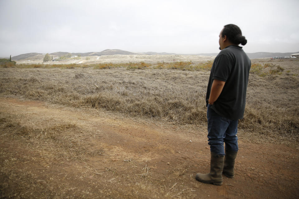 Kumu Micah Kamohoalii looks out at smoke from a wildfire near Waimea, Hawaii, Wednesday, Aug. 4, 2021. The area was scorched by the state's largest-ever wildfire. (AP Photo/Caleb Jones)