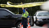 <p>An Austin police officer raises a barrier near the site of Sunday’s explosion, Monday, March 19, 2018, in Austin, Texas. (Photo: Eric Gay/AP) </p>