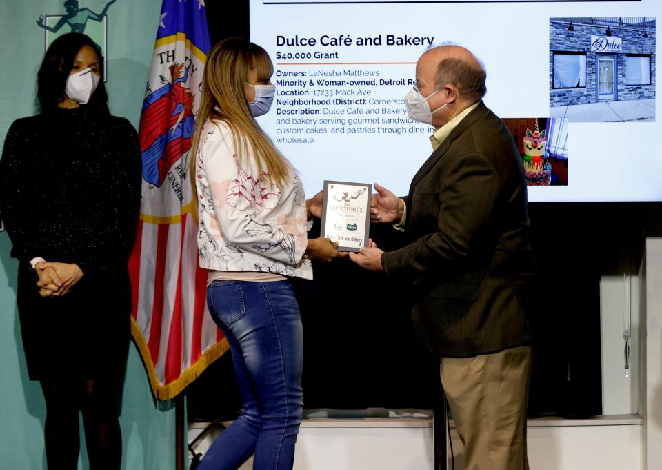 LaNesha Matthews, owner of Dulce Cafe and Bakery accepts her award from Detroit Mayor Mike Duggan as Detroit City Council President Mary Sheffield looks on at the Detroit Public Safety Headquarters in Detroit on Wednesday, Jan. 26, 2022. Motor City Match awarded $8.6 million in cash grants. Eighty-one percent of the overall winners are minority-owned businesses and 71% are female-owned.