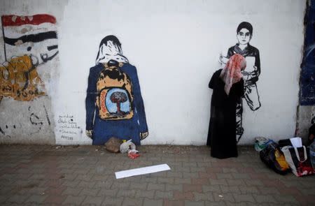 An artist paints a mural as part of the "Silent Victims" campaign to depict the suffering of women and children in the war-torn Yemen, in Sanaa, Yemen March 1, 2018. REUTERS/Mohamed al-Sayaghi