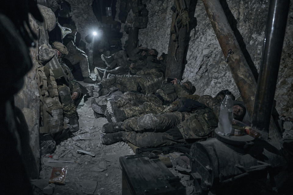 Soldiers of the Ukrainian 3rd Army Assault Brigade of the Special Operations Forces (SSO) "Azov" rest in a blindage after night fight near Bakhmut, Donetsk region, Ukraine, Saturday, Feb. 11, 2023. (AP Photo/Libkos)