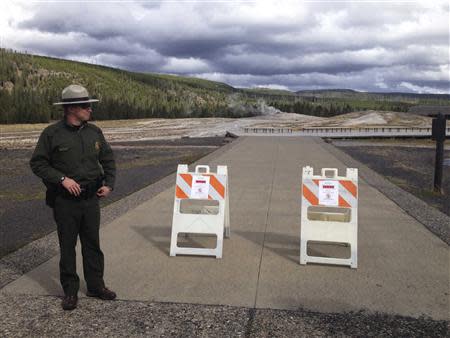 A park ranger next to a sign announcing the closure of the Old Faithful Geyser is pictured at Yellowstone National Park in Wyoming October 1, 2013 in the wake of the government shutdown. REUTERS/Christopher Cauble