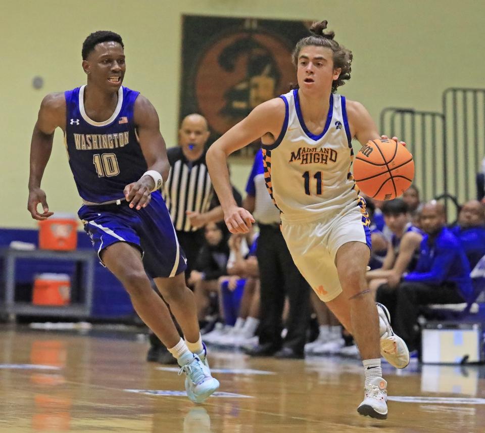 Mainland’s Kade Manley (11) dribbles past his defender against Booker T. Washington during the Region 1-5A hosted by Mainland on Tuesday, Feb.20, 2024.