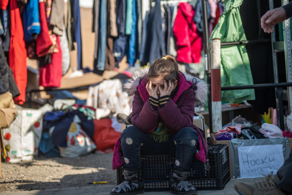 A girl, a refugee from the Ukrainian war, exhaustedly holds her head in her hands in the Medika refugee camp, Poland. (