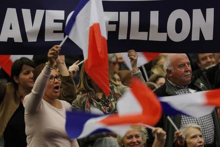 Supporters of Francois Fillon, former French prime minister and member of Les Republicains political party, wave flags as they attend a campaign rally in the second round for the French center-right presidential primary election in Paris, France, November 25, 2016. REUTERS/Philippe Wojazer