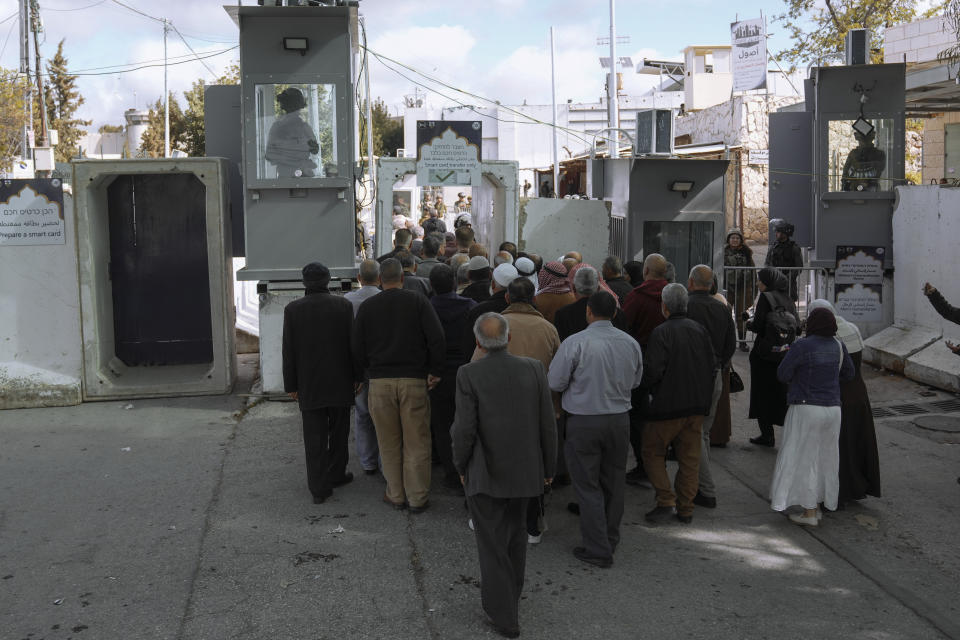 Palestinians go through a security check by Israeli soldiers as they cross from the West Bank city of Bethlehem to Jerusalem to participate in Friday prayers at the Al-Aqsa Mosque compound during the Muslim holy month of Ramadan on Friday, March 15, 2024. (AP Photo/Mahmoud Illean)