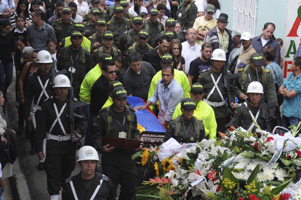 Relatives and fellow police officers carry the coffin containing the body of police officer Andres Rodriguez during his funeral service in Guarne, Colombia, Monday, April, 30, 2012. Colombia's Defense Minister Juan Carlos Pinzon said his government has not launched any special rescue mission for Romeo Langlois, a French journalist who was accompanying a counterdrug mission when it was attacked by leftist rebels on Saturday, killing Rodriguez. (AP Photo/Luis Benavides)