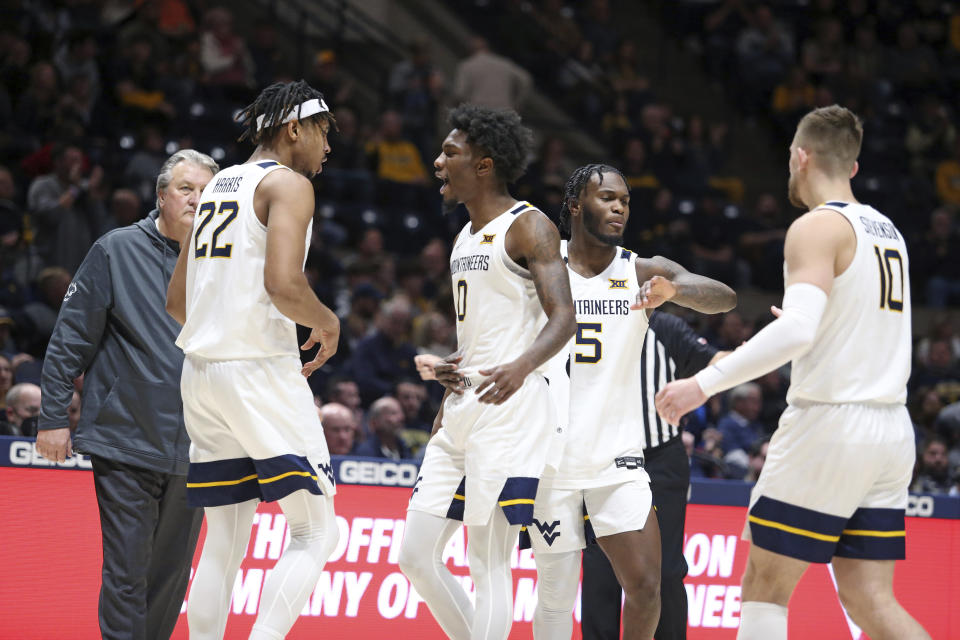 West Virginia players celebrate during the first half of an NCAA college basketball game against Buffalo in Morgantown, W.Va., Sunday, Dec. 18, 2022. (AP Photo/Kathleen Batten)