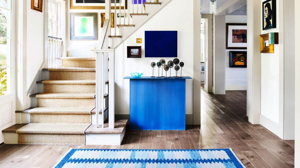 stairs with tan runner and blue art