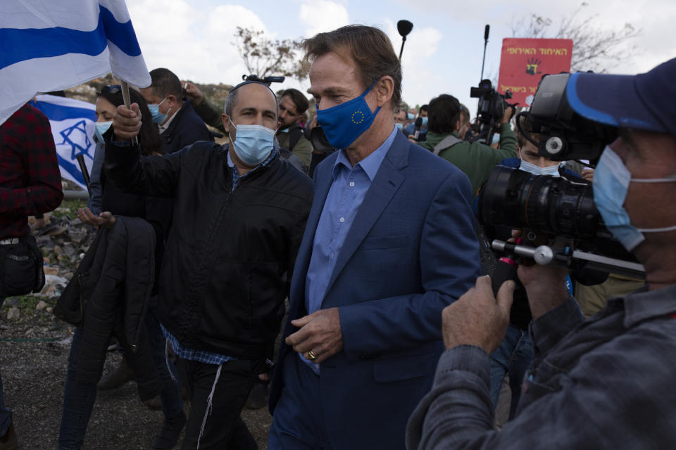 Sven Kuhn von Burgsdorff, the European Union representative for the Palestinian Territories, is heckled by a protester as he visits the construction site for Givat Hamatos settlement in Jerusalem, Monday, Nov. 16, 2020. The Israel Land Authority announced on its website Sunday that it had opened up tenders for more than 1,200 new homes in the settlement of Givat Hamatos, according to the Israeli anti-settlement group Peace Now. (AP Photo/Maya Alleruzzo)