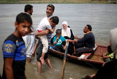 Displaced Iraqis react as others get in a boat to cross the Tigris River after the bridge has been temporarily closed, in western Mosul, Iraq May 6, 2017. REUTERS/Suhaib Salem