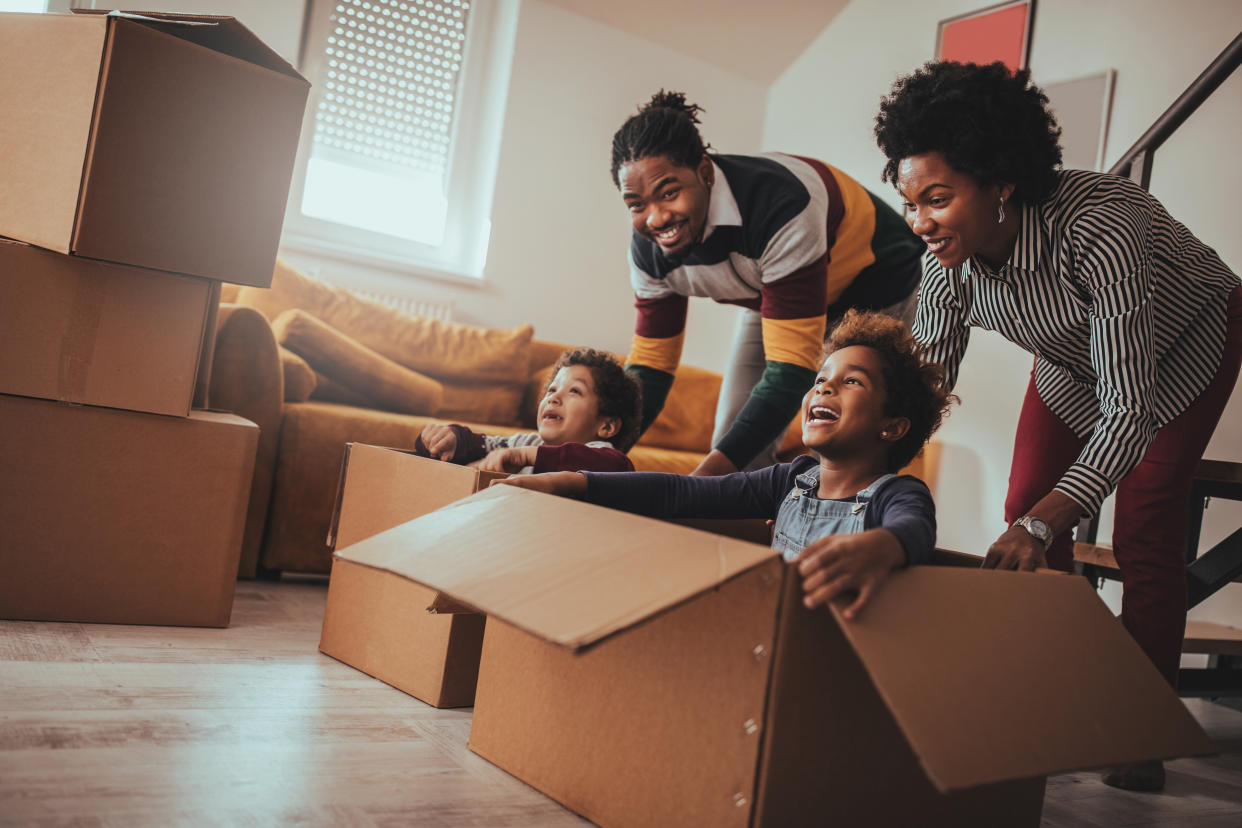 Parents and their children playing while moving into a new house