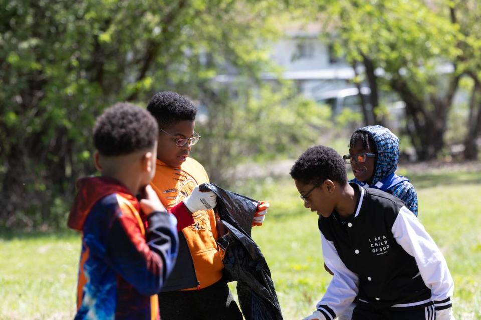 Children from St. Louis and East St. Louis unfold a trash bag during an Earth Day cleanup on April 20, 2024.