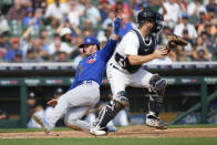 Chicago Cubs' Ian Happ scores as Detroit Tigers catcher Jake Rogers waits for the throw at home plate in the eighth inning of a baseball game, Wednesday, Aug. 23, 2023, in Detroit. (AP Photo/Paul Sancya)