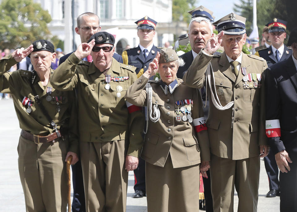 Polish officials and war veterans pay tribute to a World War II-era underground force that collaborated with Nazi German forces toward the end of the war in their battle against the Communists, who were imposing control on the nation, in Warsaw, Poland, Sunday, Aug. 11, 2019. President Andrzej Duda's official patronage and the presence of ruling party officials underlined the right-wing government's rehabilitation of a partisan unit that fought both Germans and Soviets and which is celebrated by the far right .(AP Photo/Czarek Sokolowski)