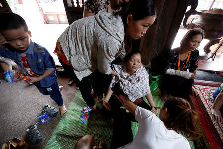 Relatives assist Nguyen Thi Xuyen (C), during a ritual Hau Dong ceremony at Phu Day temple in Nam Dinh province, Vietnam, May 7, 2017. REUTERS/Kham