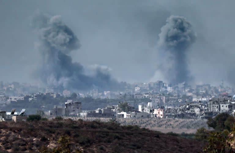 Imagen tomada desde la ciudad israelí de Sderot muestra polvo negro y humo ascendiendo este sábado en la Franja de Gaza palestina, en medio de las batallas en curso entre Israel y el grupo islamista palestino Hamás. (Photo by Thomas COEX / AFP)
