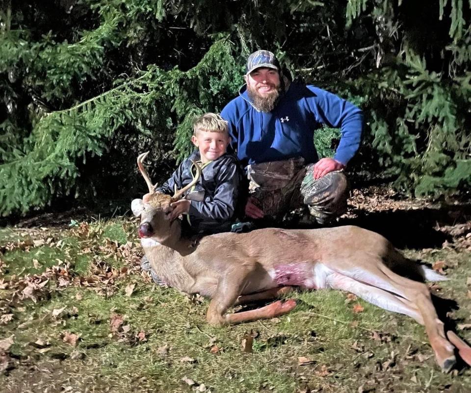 James White, right, poses with his girlfriend's son George as George poses with the first deer he successfully hunted.