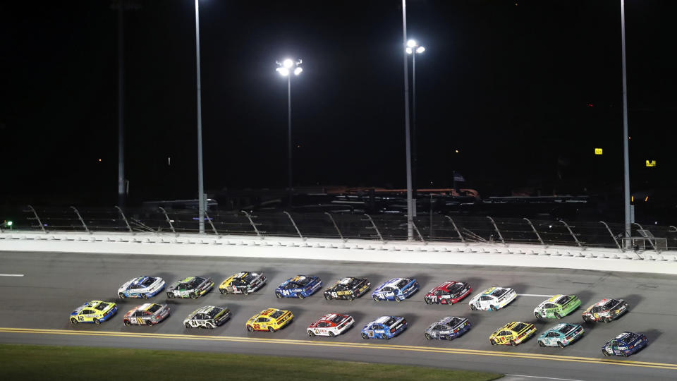 Ryan Blaney, lower far left, and Ross Chastain, right, lead the field during early laps of the first of two qualifying auto races for the NASCAR Daytona 500 at Daytona International Speedway, Thursday, Feb. 16, 2023, in Daytona Beach, Fla. (AP Photo/David Graham)